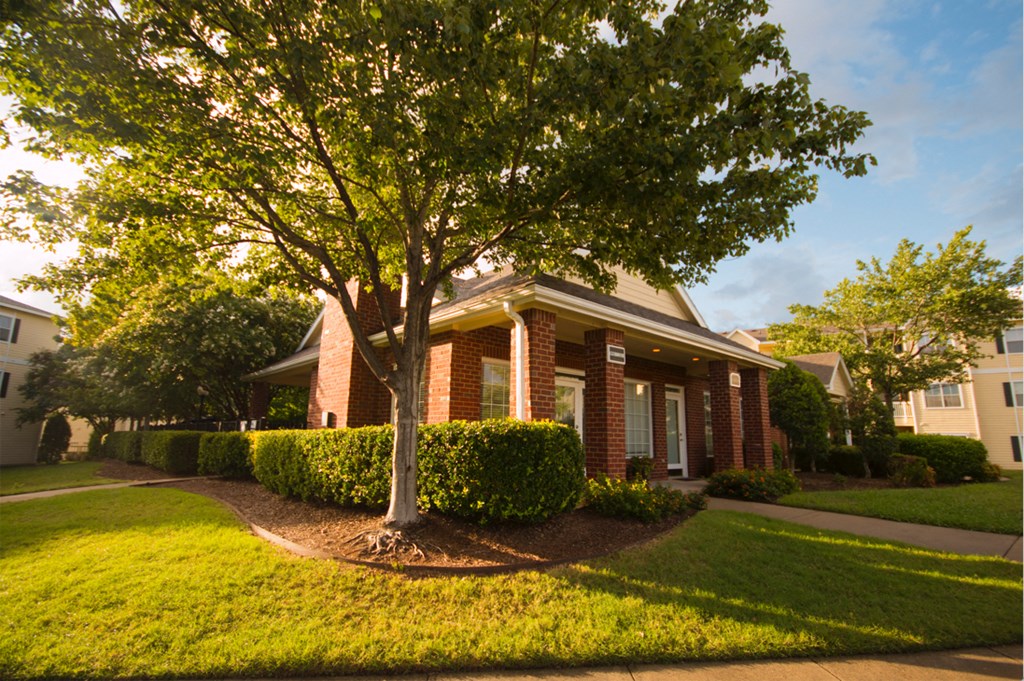 a small brick house with a tree in front of it