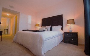 a bedroom with a large bed and a night stand