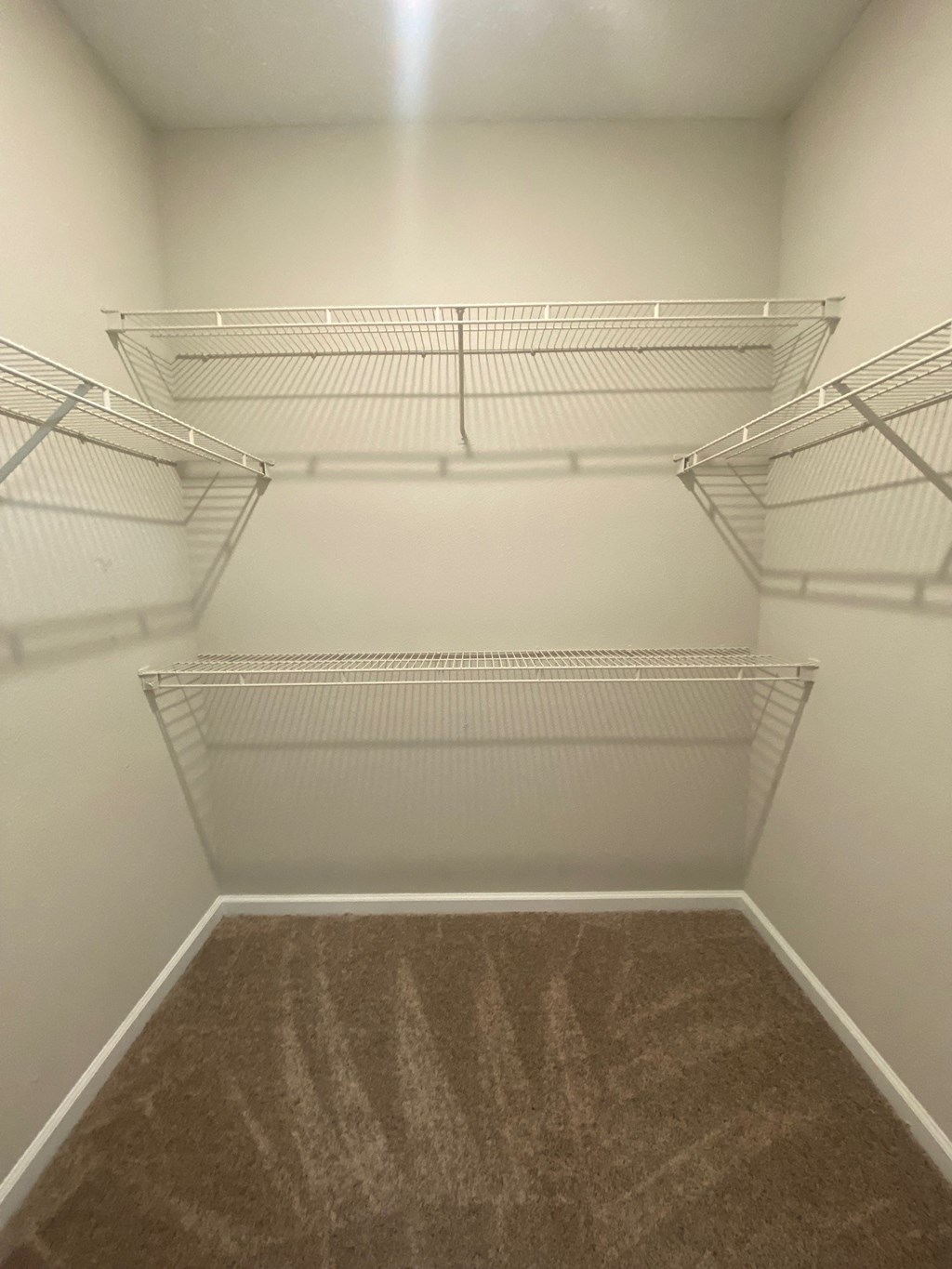 a spacious walk in closet in a home with empty shelves