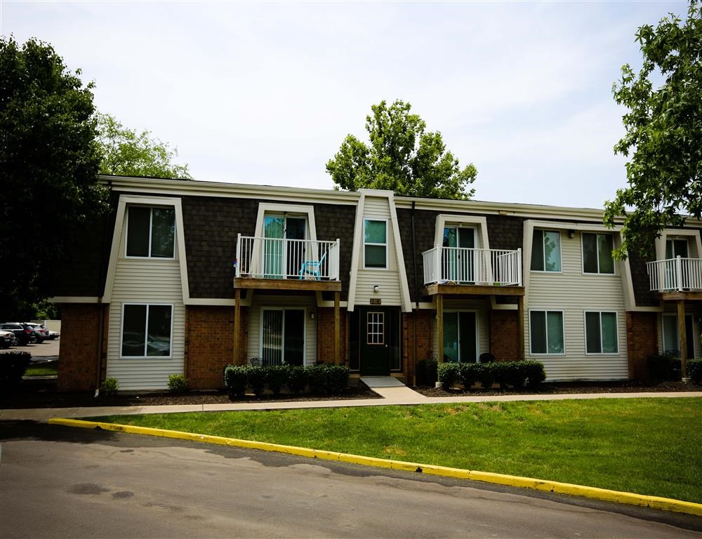 an apartment building with two balconies and a street in front