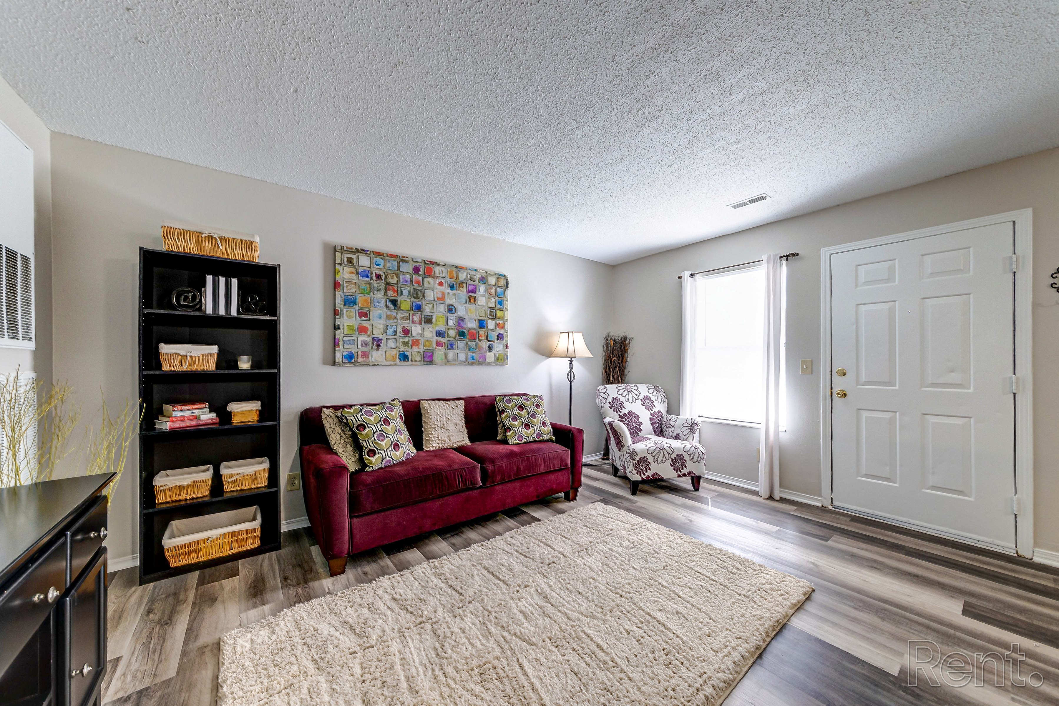 a living room with a couch and a chair and a door