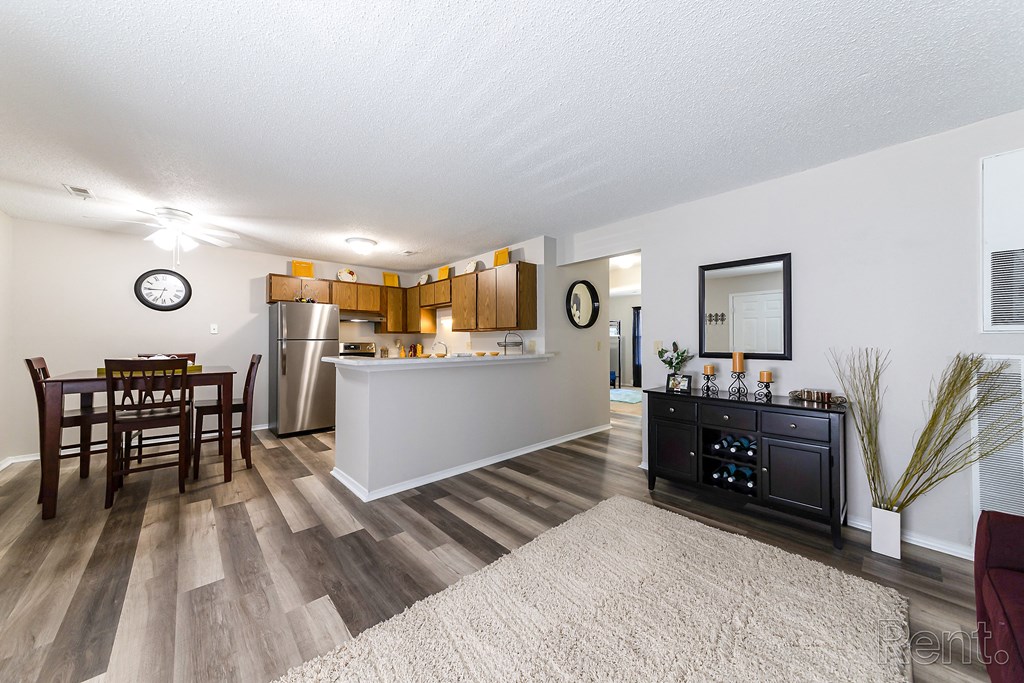 a living room with a dining room and a kitchen with a table and chairs