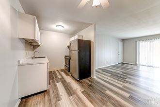 a kitchen with white cabinets and a stainless steel refrigerator