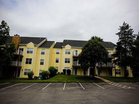 an empty parking lot in front of an apartment building