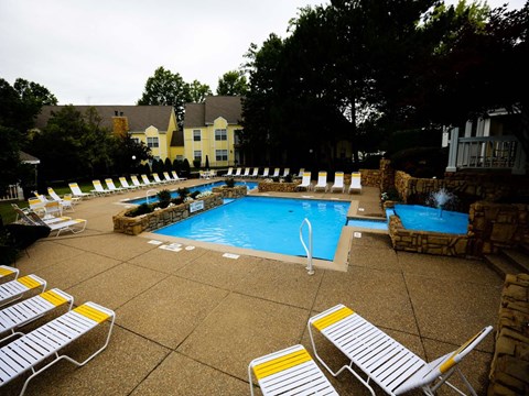 a swimming pool with lounge chairs around it