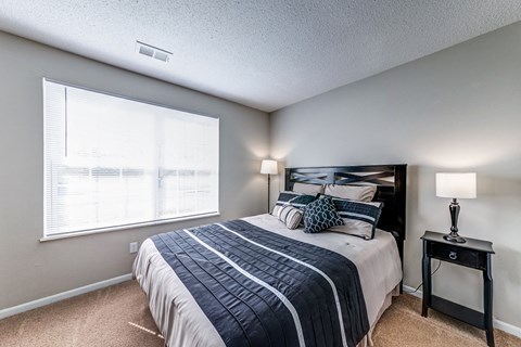 the master bedroom has a large window and a large bed