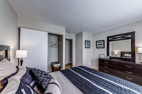 the master bedroom has a king sized bed and a large mirror