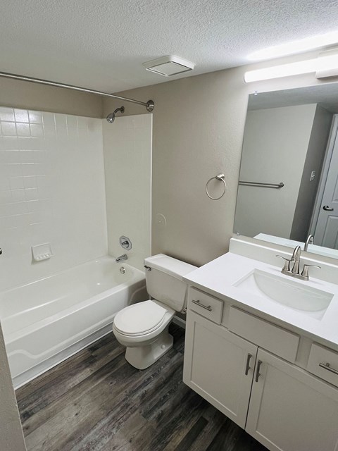 A white toilet sits in a bathroom next to a sink.
