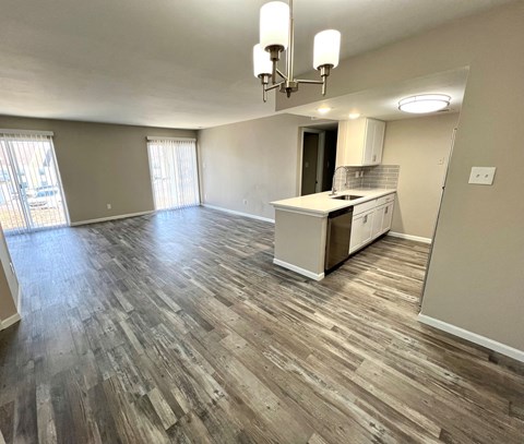 A kitchen with wooden flooring and a white cabinet.