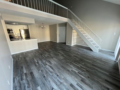 A spacious room with a staircase leading to the upper floor.