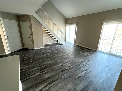 A room with a staircase and wooden flooring.
