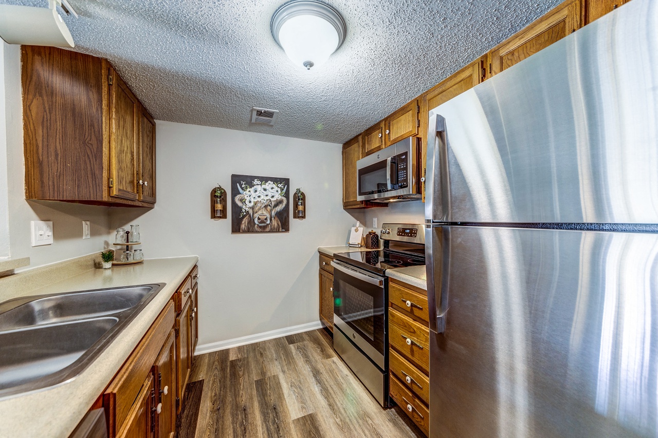 the kitchen has stainless steel appliances and wooden cabinets