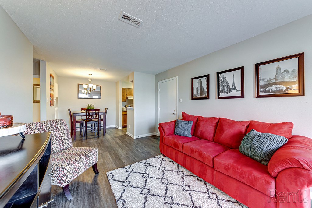 a living room with a red couch and a dining room table
