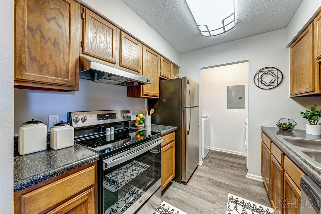 a kitchen with wood cabinets and stainless steel appliances and a refrigerator