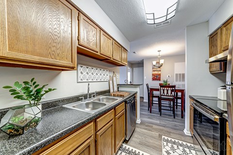 a kitchen with wooden cabinets and a stainless steel sink