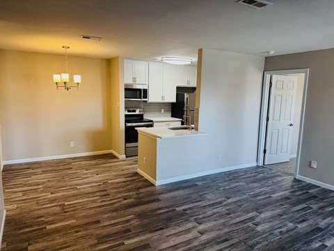 A kitchen area with a wooden floor and a white island.