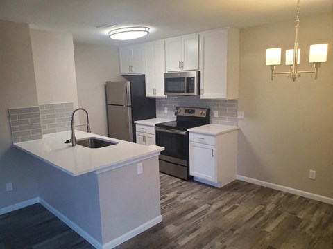 A kitchen with a sink, stove, and refrigerator.