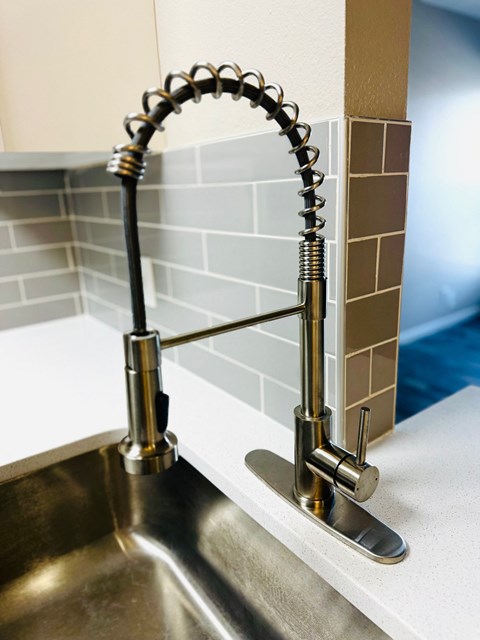 A chrome kitchen faucet with a pull out sprayer.