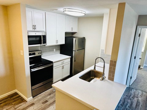 A kitchen with black and white appliances and a white countertop.