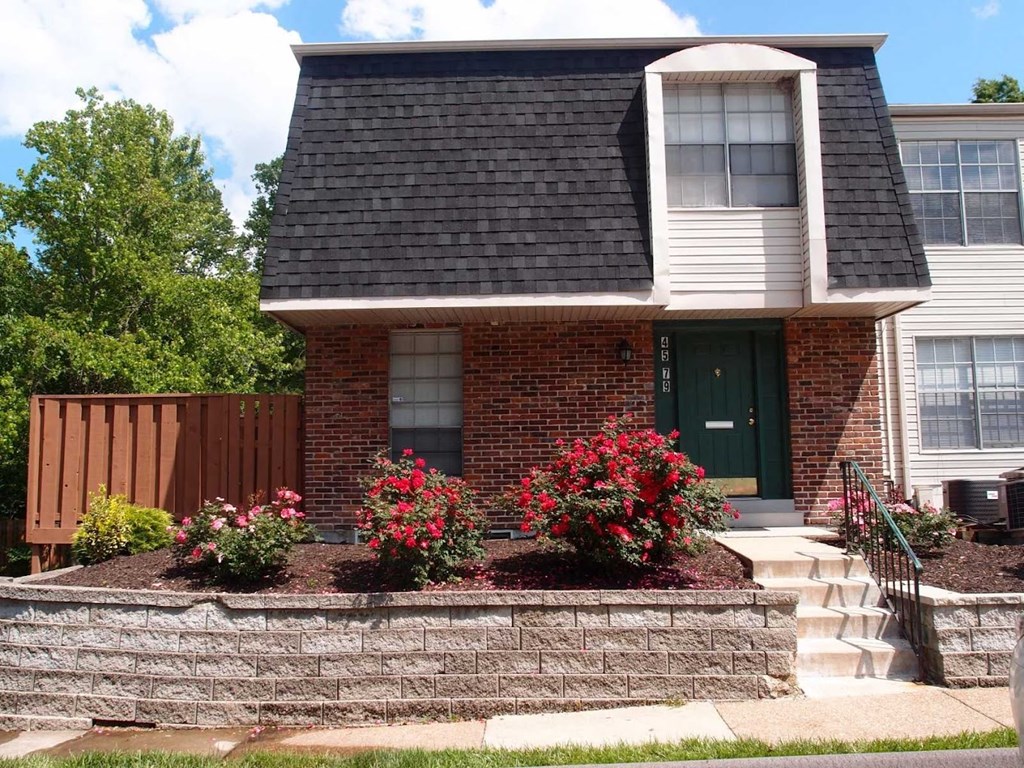 a house with a stone retaining wall in front of it