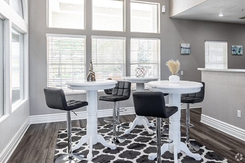 a dining room with tables and chairs in front of a window