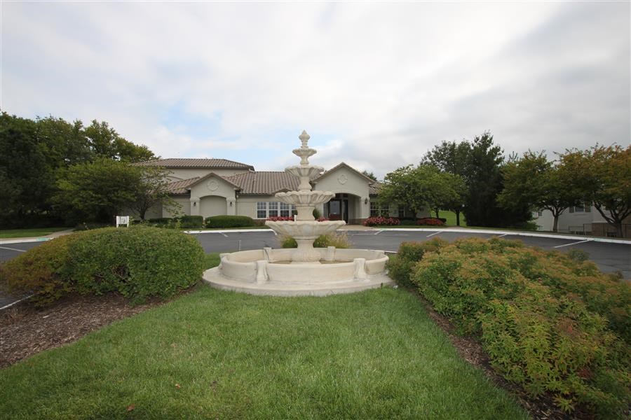 a fountain in a yard in front of a house