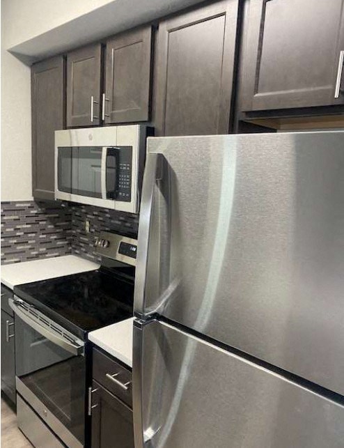 a kitchen with a stainless steel refrigerator and a microwave