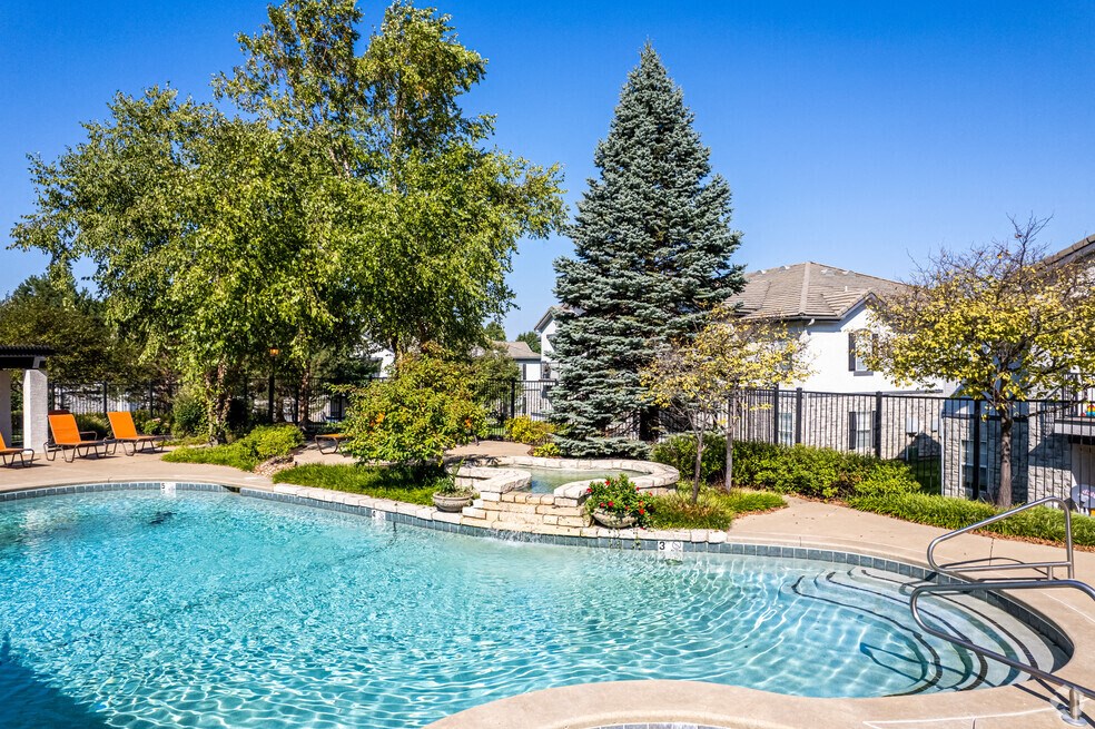 a swimming pool with trees and a house in the background