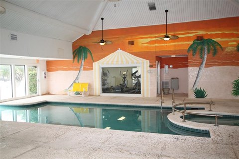 a swimming pool with a fountain and palm trees