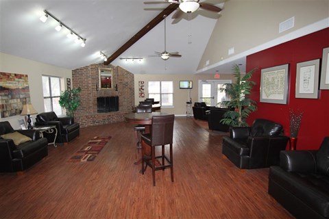 a living room with leather furniture and a red wall