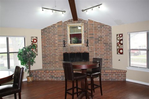a dining room with a brick wall and a table and chairs