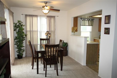 a dining room with a table and chairs and a ceiling fan