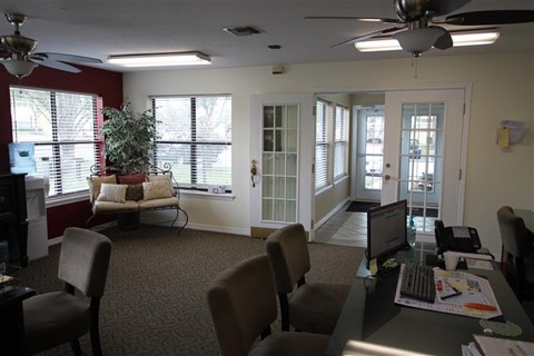 a living room with a computer desk and chairs