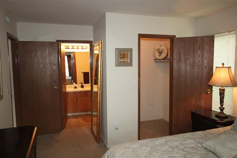a bedroom with a bed and a mirror and a bathroom