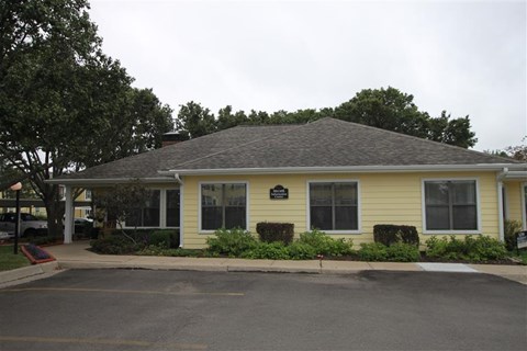 a yellow house with a black sign on the front of it