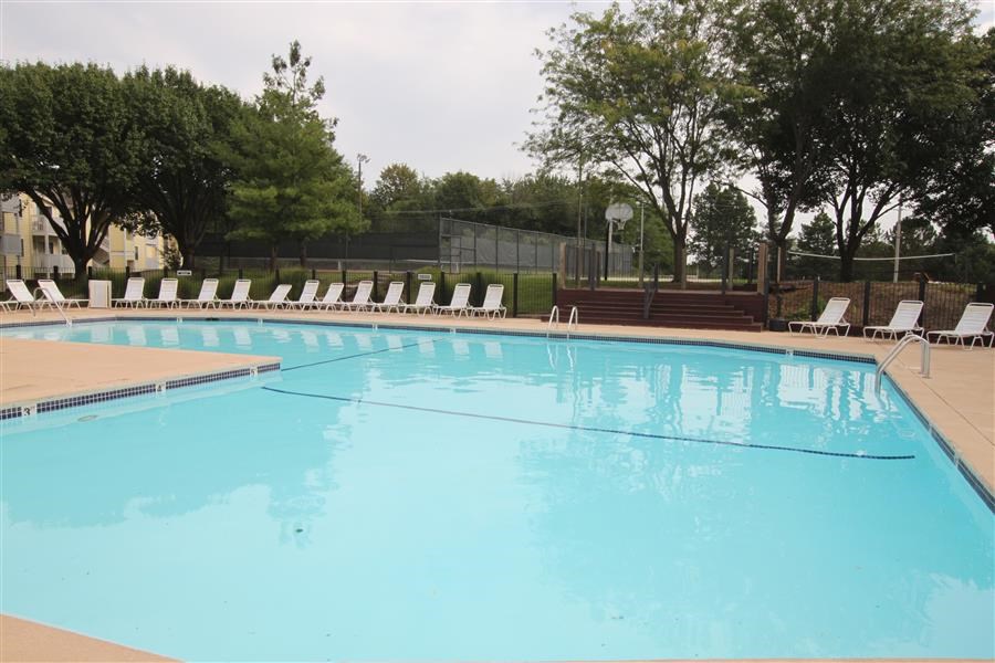 a large blue pool with white chairs around it