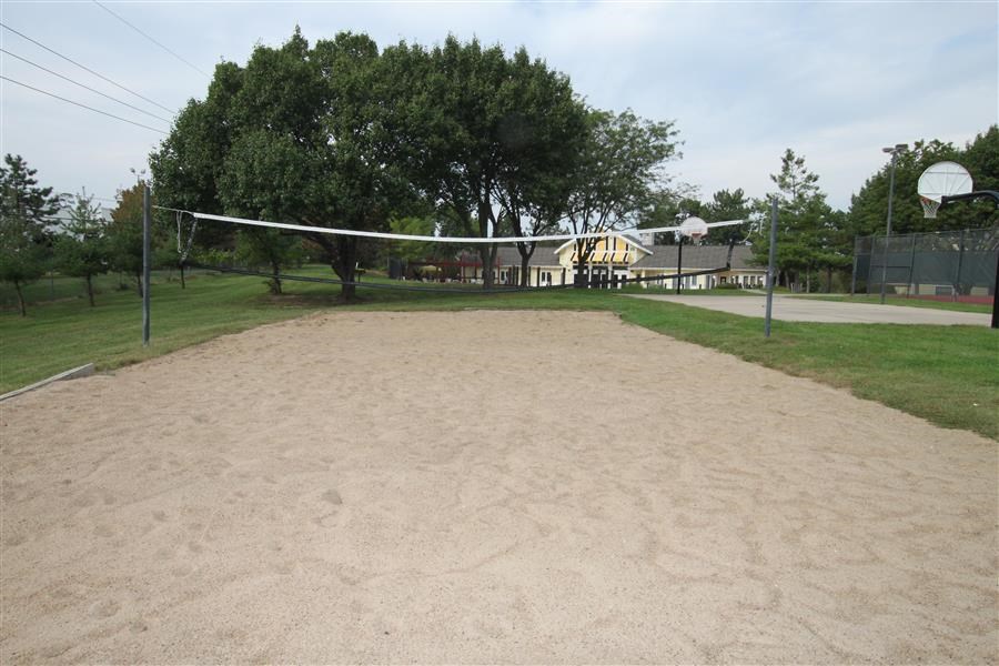 a sandy volleyball court in the middle of a park