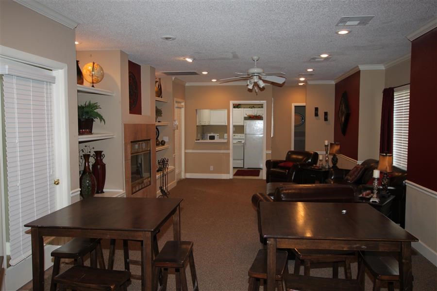 a living room with a table and a ceiling fan