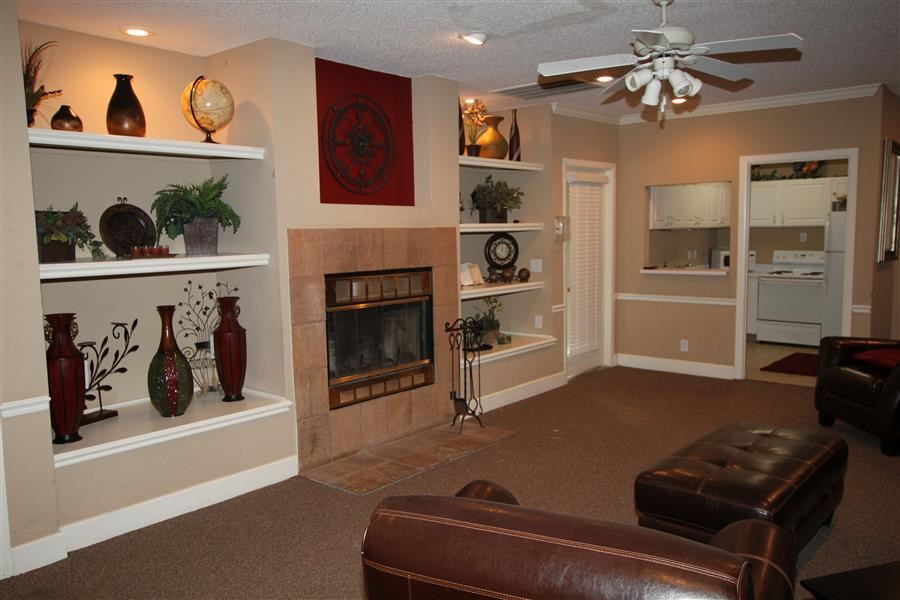 a living room with a fireplace and leather furniture