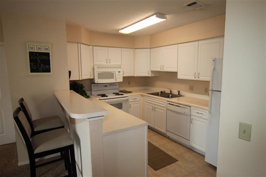 a kitchen with white cabinets and a sink and a microwave
