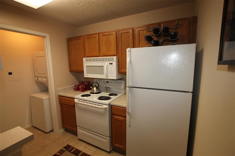a small kitchen with a white refrigerator and stove