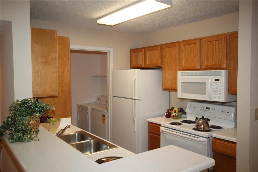 a kitchen with white appliances and wooden cabinets