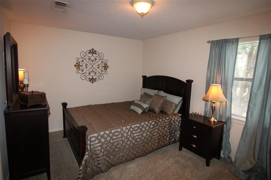 a bedroom with a bed and a night stand