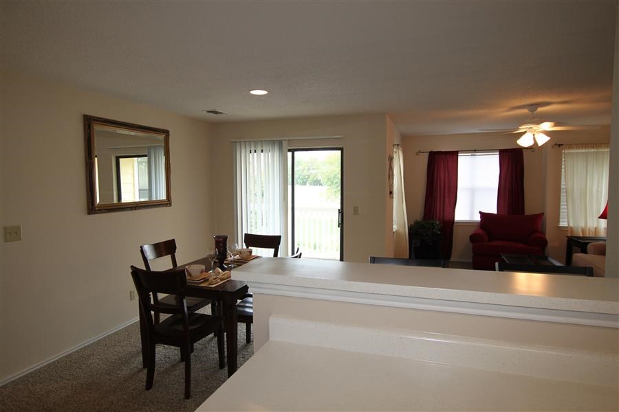 a living room with a bar and a dining table