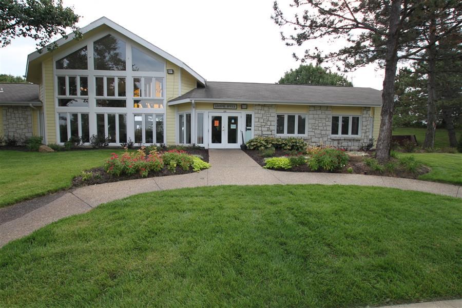 the front of a house with a walkway and grass