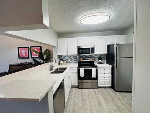 a kitchen with stainless steel appliances and white cabinets