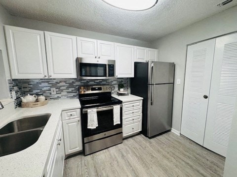 a kitchen with stainless steel appliances and white cabinets