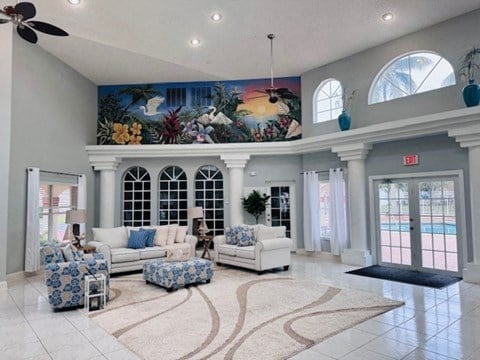 a large living room with furniture and a mural on the ceiling