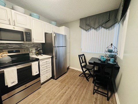 a kitchen with stainless steel appliances and a table and chairs