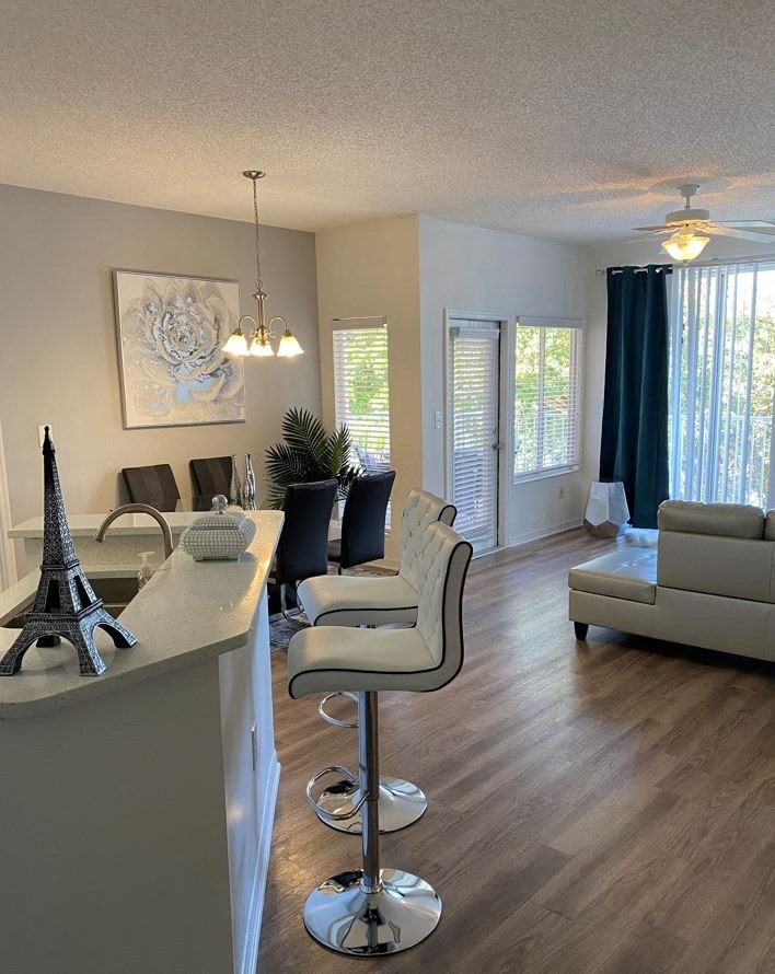 a living room with a couch and a bar with chairs